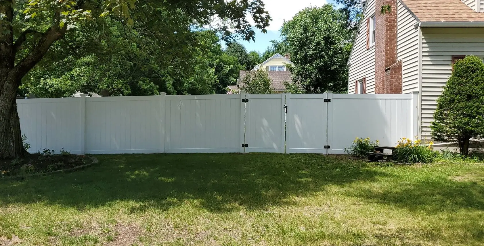 Tall residential privacy fence with double gate