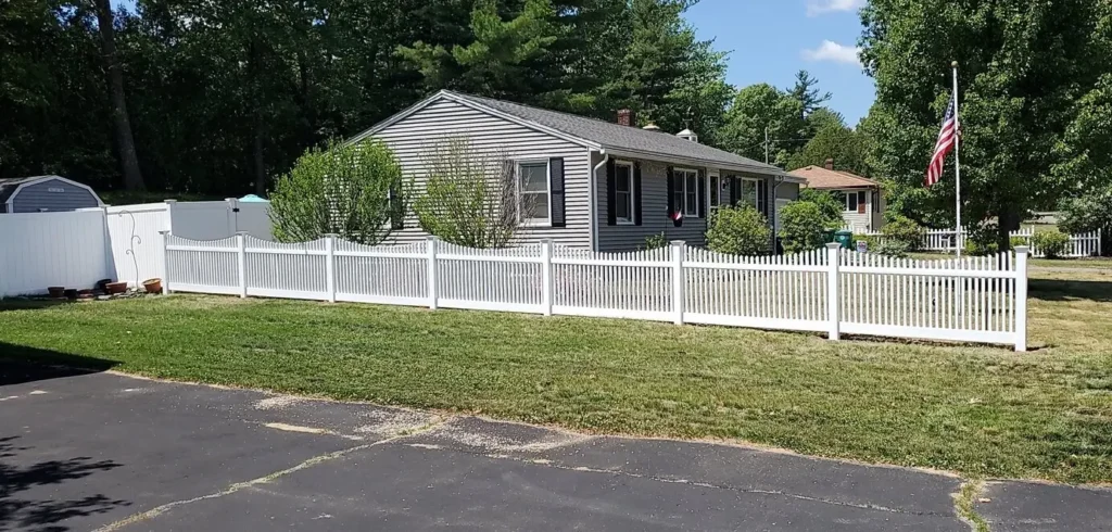 Front yard enclosed by white vinyl picket fence