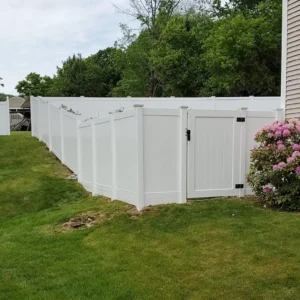 White vinyl privacy fence with closed gate.