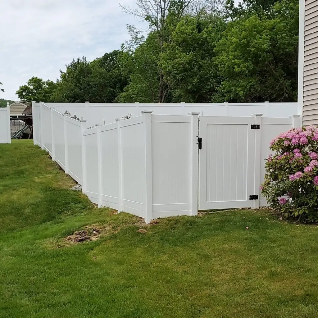White vinyl privacy fence with closed gate.
